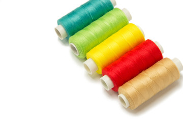 Closeup of red, yellow, golden and green threads isolated on white background. Hand made objects