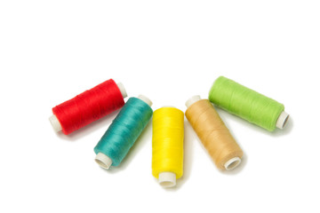 Closeup of red, yellow, golden and green threads isolated on white background. Hand made objects
