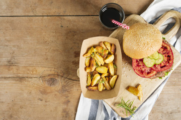 Flat-lay burger and fries on wooden board
