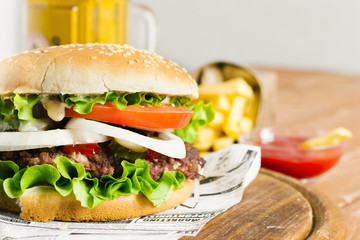 Close-up of burger and fries on wooden board