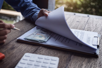 Compensation, fees, pay, bribery concept, Business man open contract document and look at  dollar...