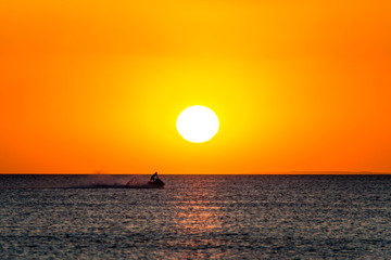 Watercraft sailing over the sea at the sunset