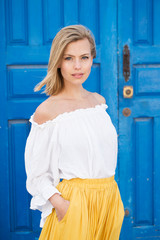 Beautiful young blond woman in white and yellow, portrait