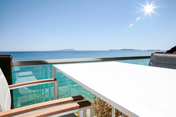 A white table background on a balcony  on a beautiful sunny blue sky and ocean view,