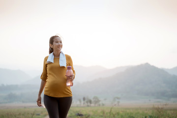 pregnant woman jogging outdoor in nature. active maternity lifestyle