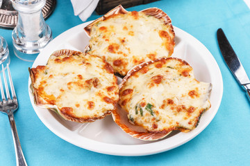 European recipe, Mediterranean dish. Baked mollusks in the oven under the cheese cap and greens according to the national recipe
