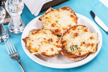 European recipe, Mediterranean dish. Baked mollusks in the oven under the cheese cap and greens according to the national recipe
