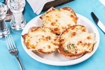 European recipe, Mediterranean dish. Baked mollusks in the oven under the cheese cap and greens according to the national recipe