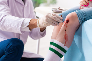 Leg injured young woman visiting male doctor