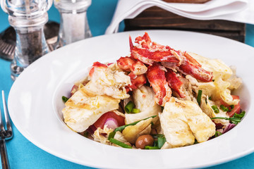  European recipe, Mediterranean dish. Roast vegetables - radish, greens, onions, olives, cabbage, with pasta in a creamy sauce with crab meat and fish pieces.