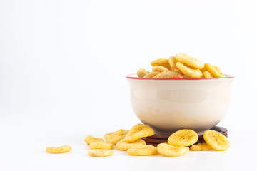 Dried banana slices in a cup isolated on white background