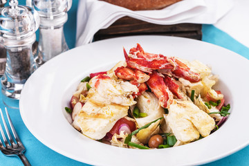  European recipe, Mediterranean dish. Roast vegetables - radish, greens, onions, olives, cabbage, with pasta in a creamy sauce with crab meat and fish pieces.