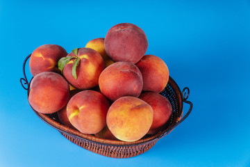 Peaches in the basket on blue background