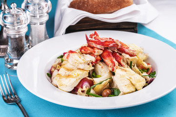  European recipe, Mediterranean dish. Roast vegetables - radish, greens, onions, olives, cabbage, with pasta in a creamy sauce with crab meat and fish pieces.