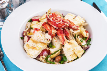  European recipe, Mediterranean dish. Roast vegetables - radish, greens, onions, olives, cabbage, with pasta in a creamy sauce with crab meat and fish pieces.