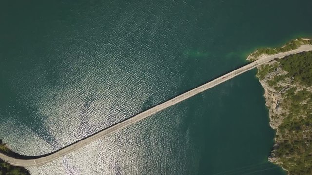 Aerial footage a car driving over a bridge on Piva Lake