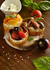 Bruschetta with soft cheese, tomatoes and basil, vertical 