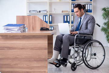 Fototapeta na wymiar Male employee in wheel-chair in the office