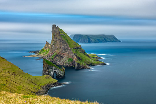 Amazing top view long exposure of Drangarnir gate in front of Tindholmur, Faroe Islands
