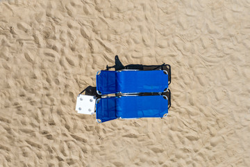 Summer umbrellas and sun beds on sandy beach. Sunbathing, relaxing and lying on the beach.