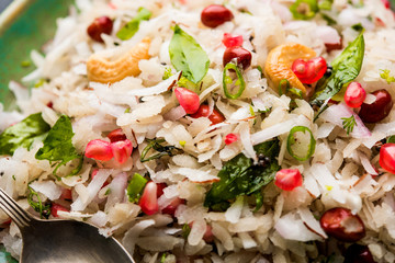Dapde Pohe is a typical Maharashtrian breakfast, made with thin variety of poha and fresh coconut with chilli, peanuts and nuts. served in a bowl or plate. selective focus