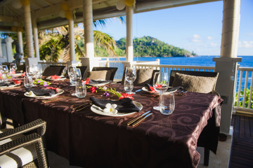 Beautiful table setting on terrace near ocean