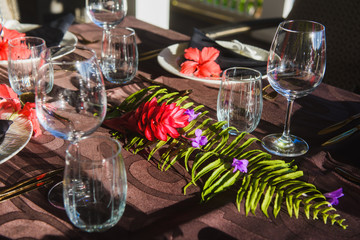 Table setting with tropic flowers and tableware
