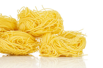 Group of four whole raw pasta angel hair closeup isolated on white background