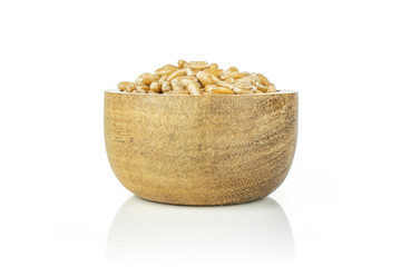 Lot of whole uncooked fresh beige dinkel wheat grain in a wooden bowl isolated on white background