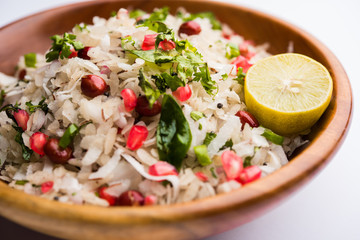 Dapde Pohe is a typical Maharashtrian breakfast, made with thin variety of poha and fresh coconut with chilli, peanuts and nuts. served in a bowl or plate. selective focus