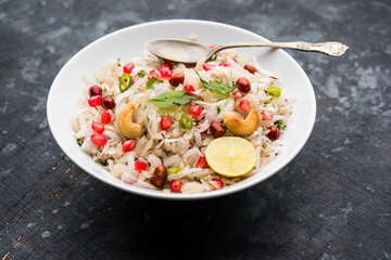 Dapde Pohe is a typical Maharashtrian breakfast, made with thin variety of poha and fresh coconut with chilli, peanuts and nuts. served in a bowl or plate. selective focus
