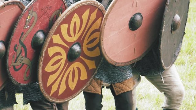 Viking warriors marching forward, shield wall. Medieval soldiers in full armor