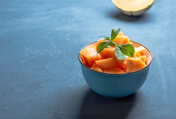 Fresh melon cut into pieces in a bowl with space for copy - image