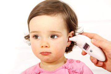 Einem Kleinkind wird im Ohr Fieber gemessen
