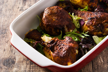 Roasted tandoori chicken with basmati rice on wooden table