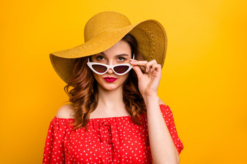 Pretty lady look window dislike rainy weather wear red dress sun specs and hat isolated yellow background