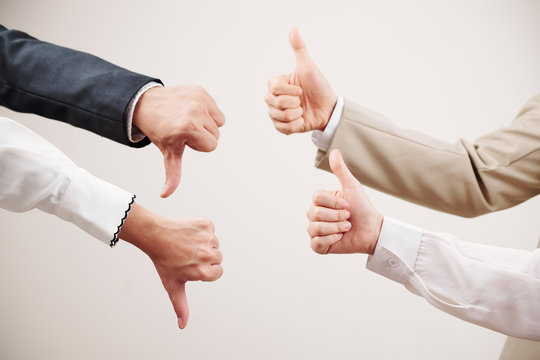 Group of two business partners showing thumb up and other two partners showing failure in business isolated on white background