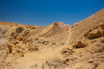 desert canyon dry scenery landscape with lonely ground trail between sharp stones and rocks