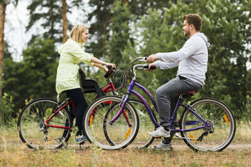 Fototapeta na wymiar Sideways happy couple on bicycles