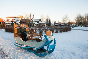 The girl on the winter sled, large sled for skiing. Girl riding a reindeer sleigh.