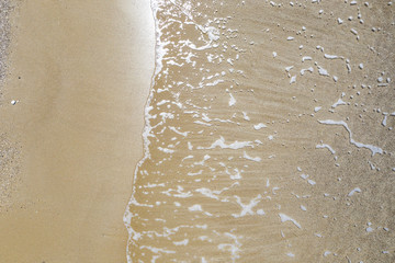 Sandy seashore with small waves.