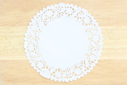 Close Up Isolated White Stencil Doily Paper Like Flower On Wood Table