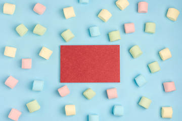 Blue paper background with marshmallow and notepad. Place for your text. Cozy sweet background