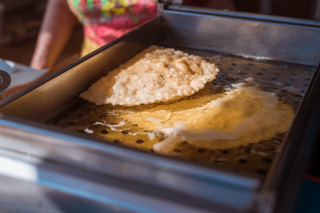 Cooking cheburek, fried patty with meat in oil.