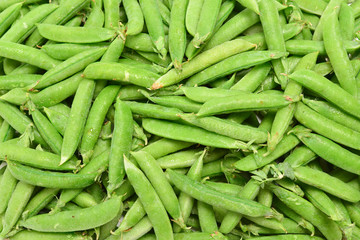 Fresh pea pods as background. Top view.