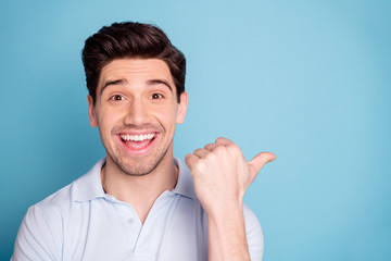 Close-up portrait of his he nice attractive cheerful cheery guy wearing casual pointing aside ad...