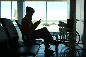 Silhouette of older woman waiting for assistance in airport