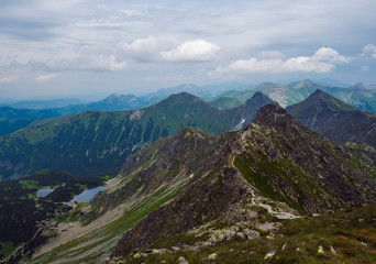 view from Banikov peak on Western Tatra mountains or Rohace panorama. Sharp green mountains - ostry rohac, placlive and volovec with hiking trail on ridge. Summer blue sky white clouds. - obrazy, fototapety, plakaty