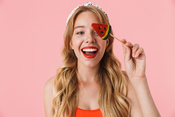 Image of gorgeous young woman with long curly hair smiling while holding watermelon candy