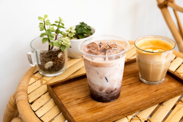Hot coffee and ice chocolate on a bamboo table
